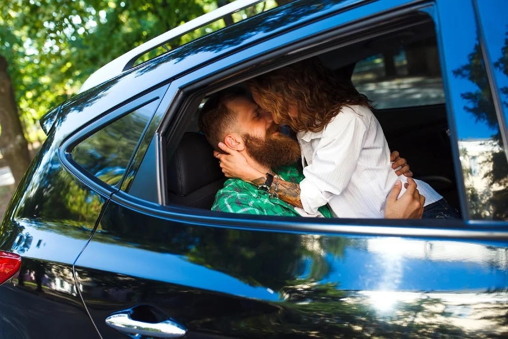 парень и девушка целуются в машине
